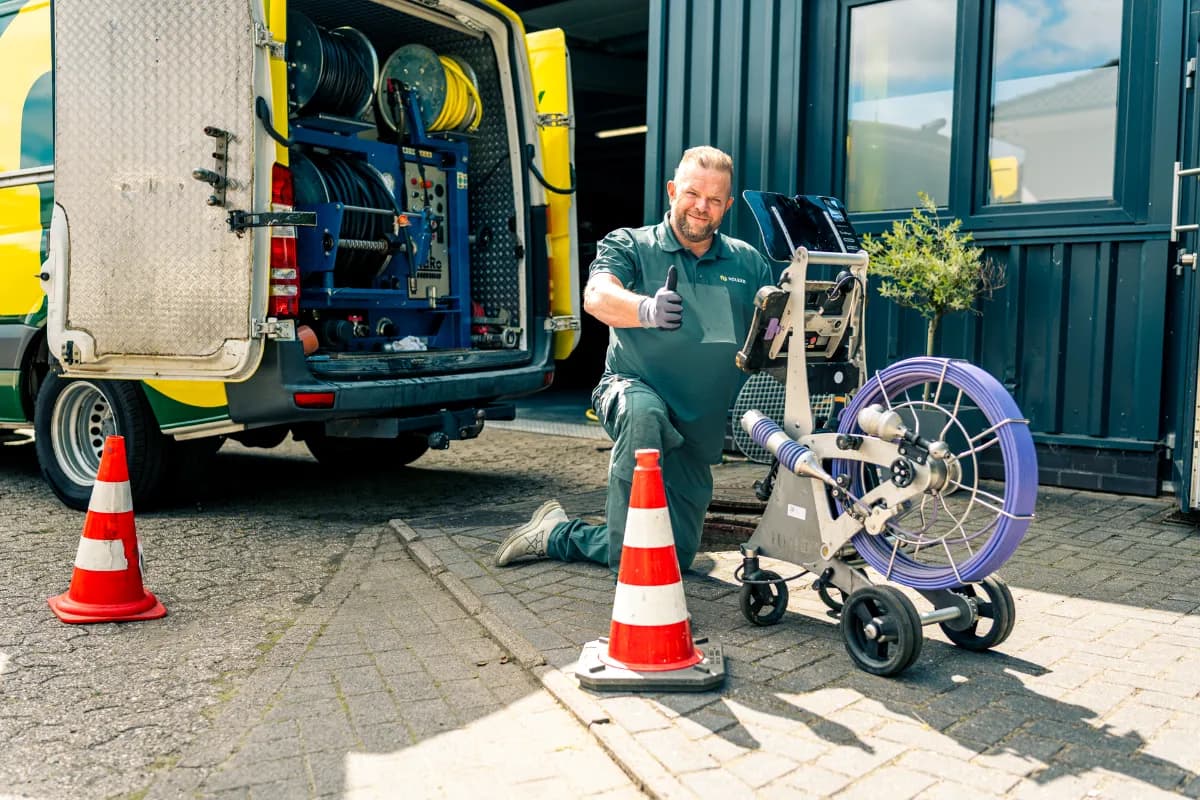 Techniker zeigt Hausbesitzer Live-Bilder aus der Kanalkamera